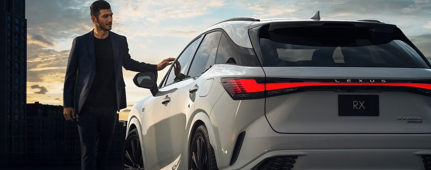 A white 2024 Lexus RX 500h is shown parked near a person.