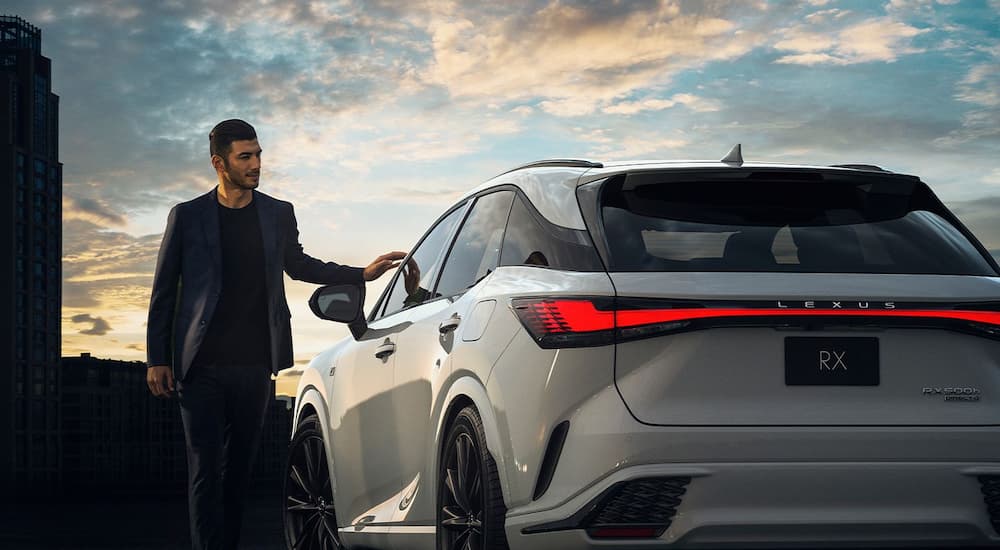 One of many popular Lexus EVs, a white 2024 Lexus RX500h F-SPORT, is shown from a rear angle. - Touch.jpg
