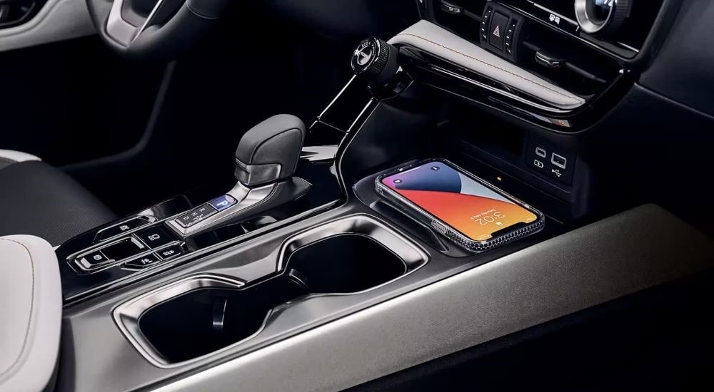 A close up shows a phone and center console in a 2024 Lexus NX 450h+.
