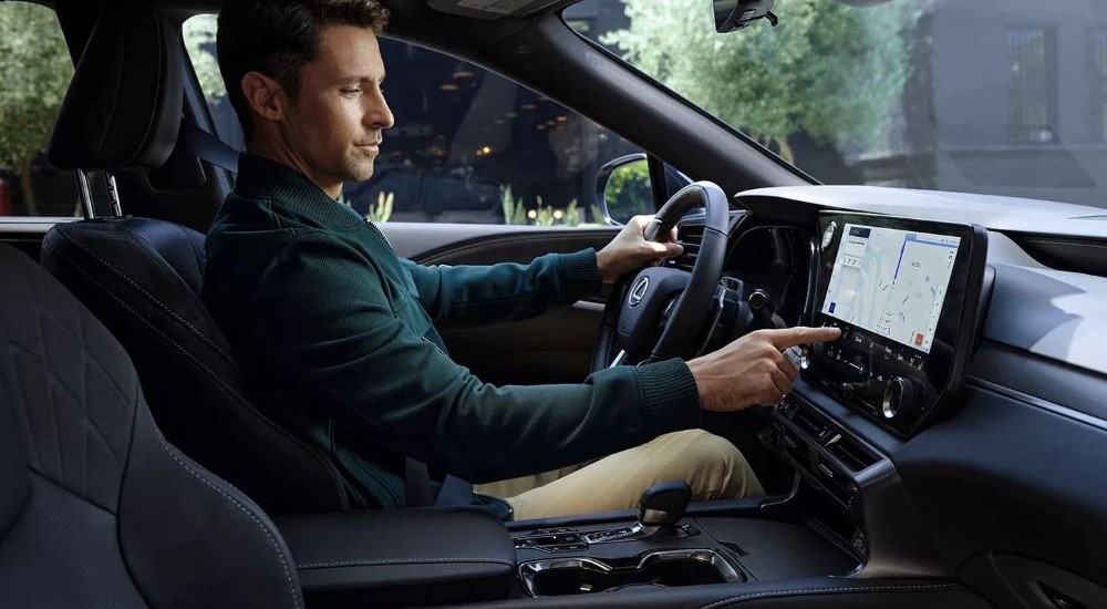 A person is shown suing the infotainment screen in a 2023 Lexus RX.