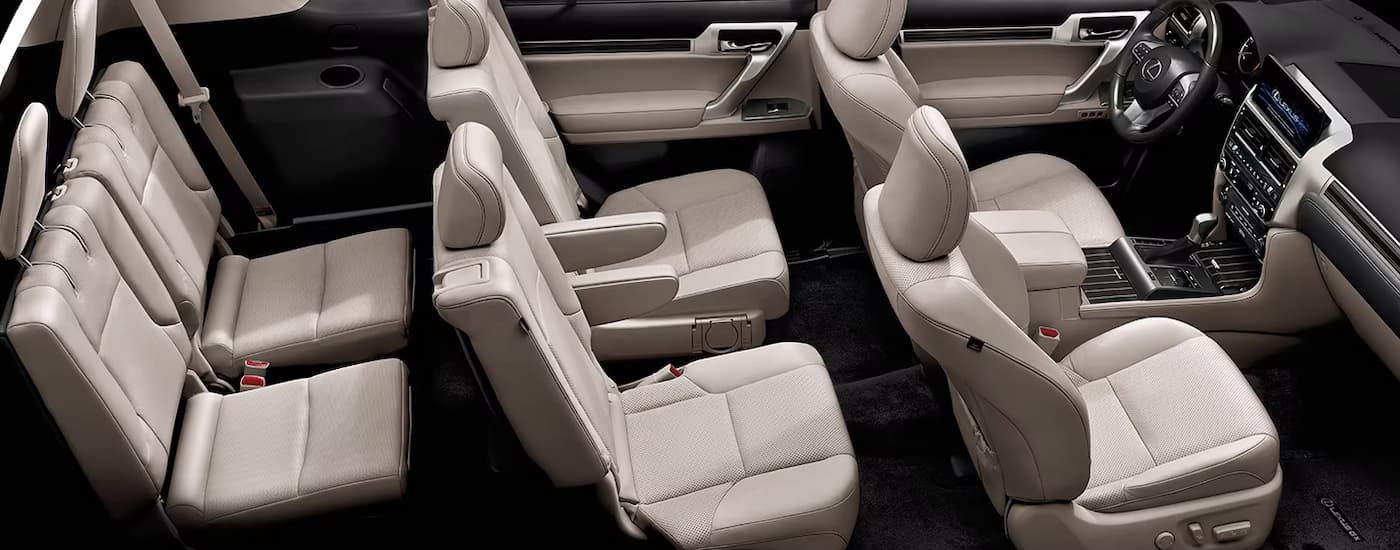 The tan interior of a 2023 Lexus GX for sale shows three rows of seating.