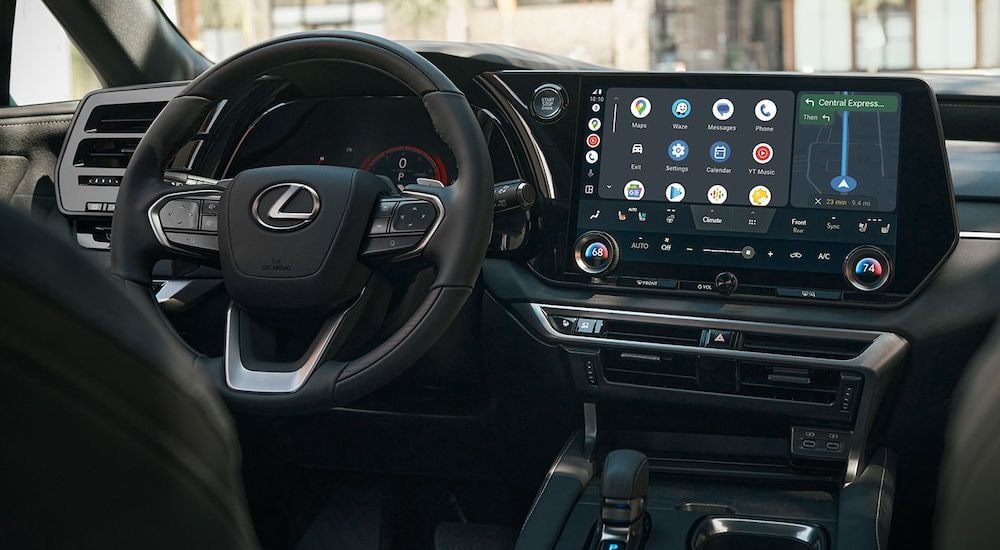 The black interior of a 2024 Lexus RX is shown from the back seat.