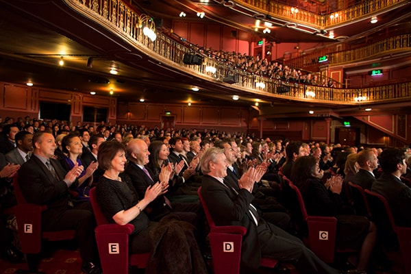 Audience applauding in performing arts theater.