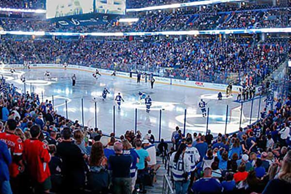 Image of a hockey game and crowd at sports arena.