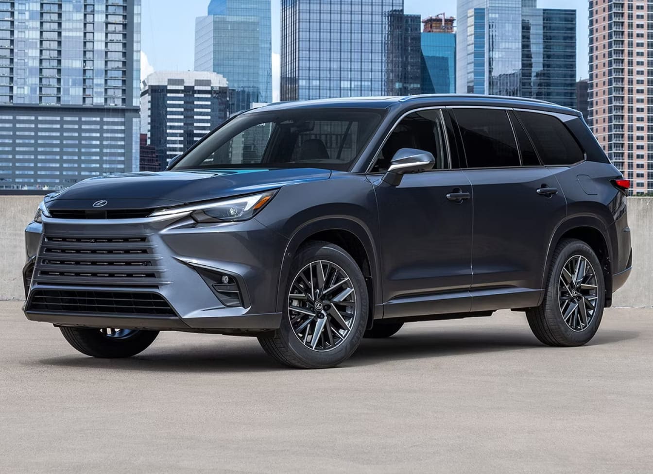 Gray Lexus TX shown in front of a city skyline.