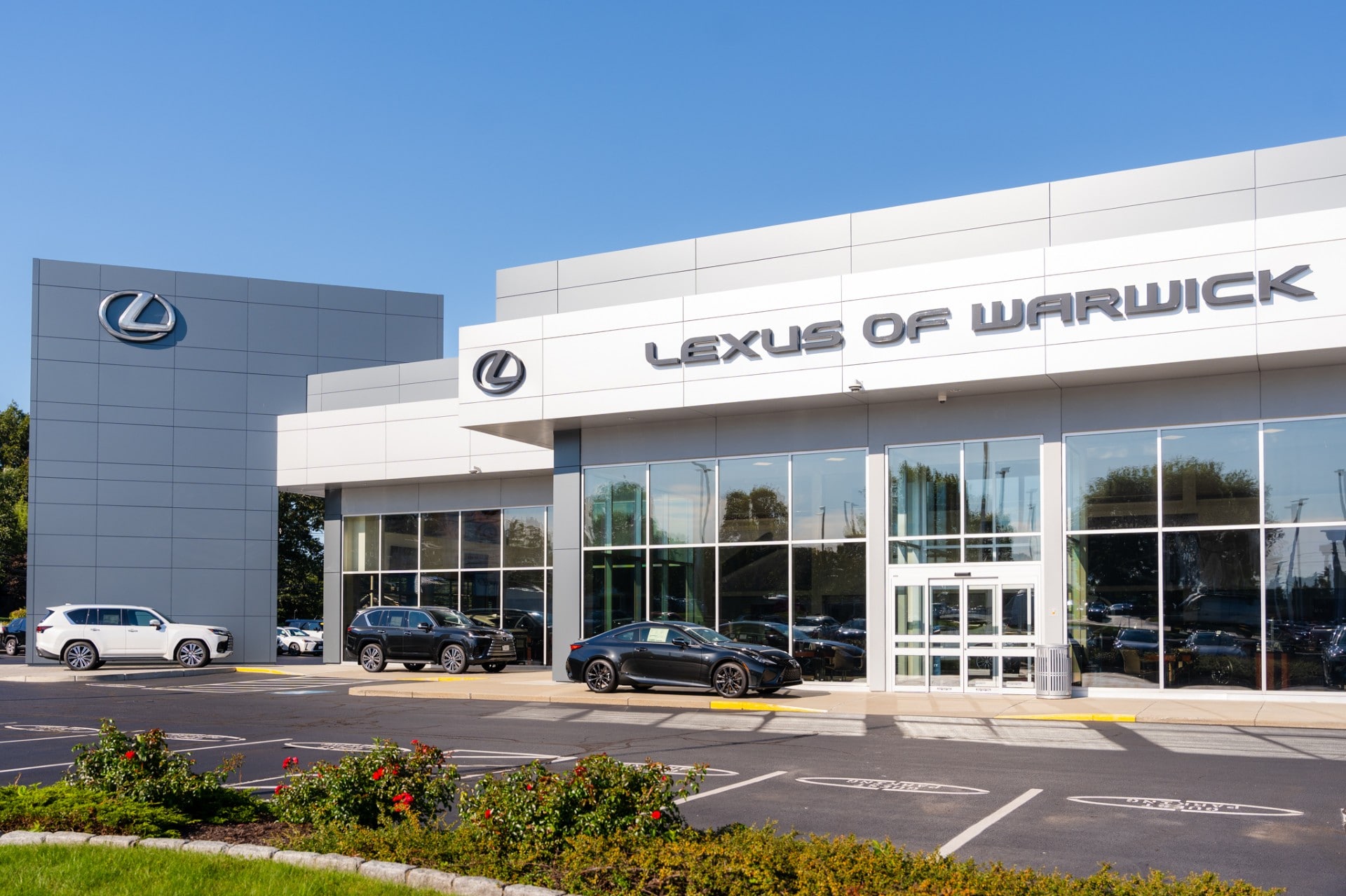 Woman reading a Lexus pamphlet in front of a red Lexus convertible