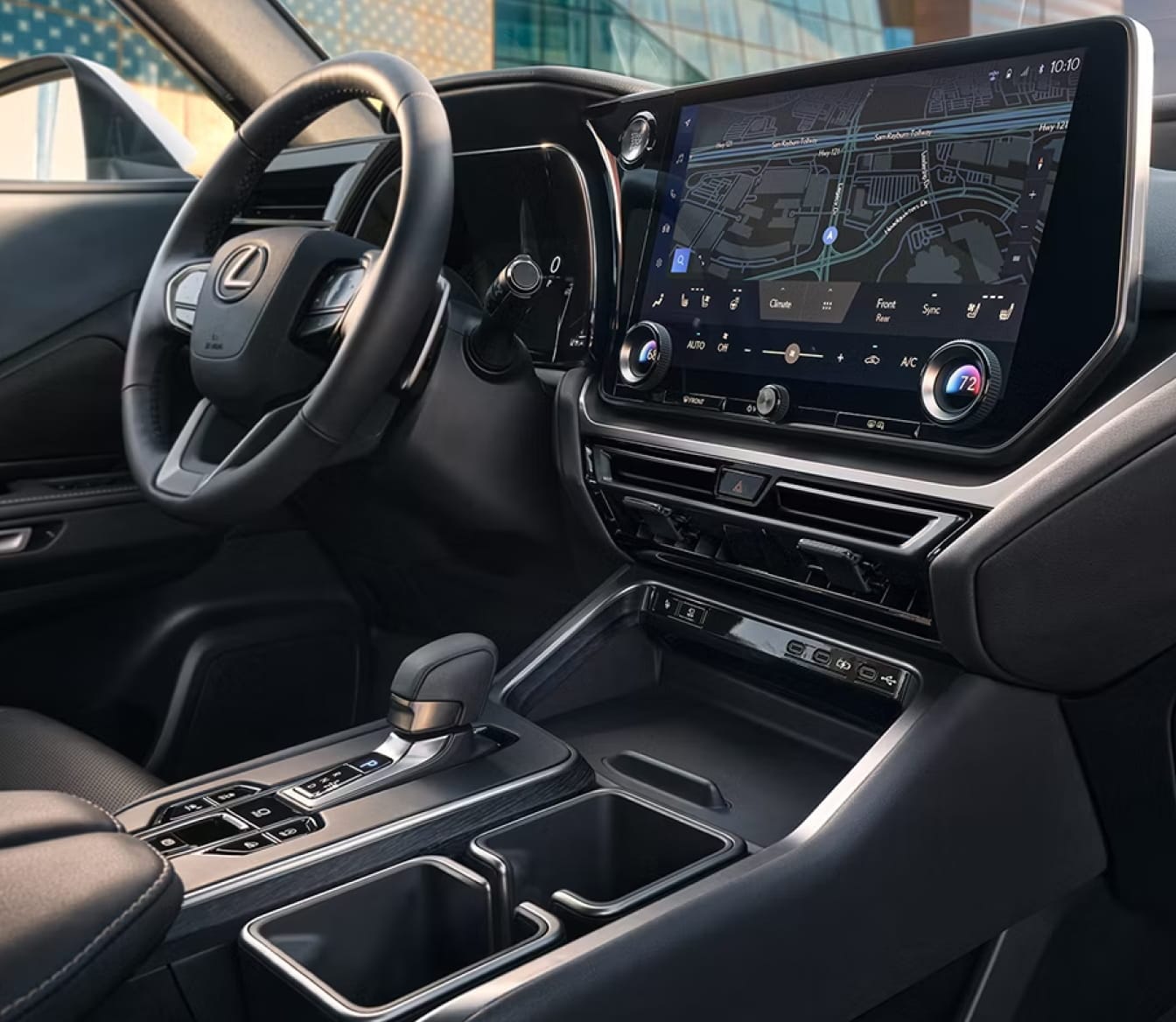 Lexus TX interior featuring a steering wheel, large touchscreen with navigation, center console, and cupholders.