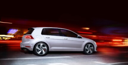 silver VW Golf GTI driving on the road at night