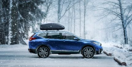 blue Honda CR-V viewed from the side in the snow