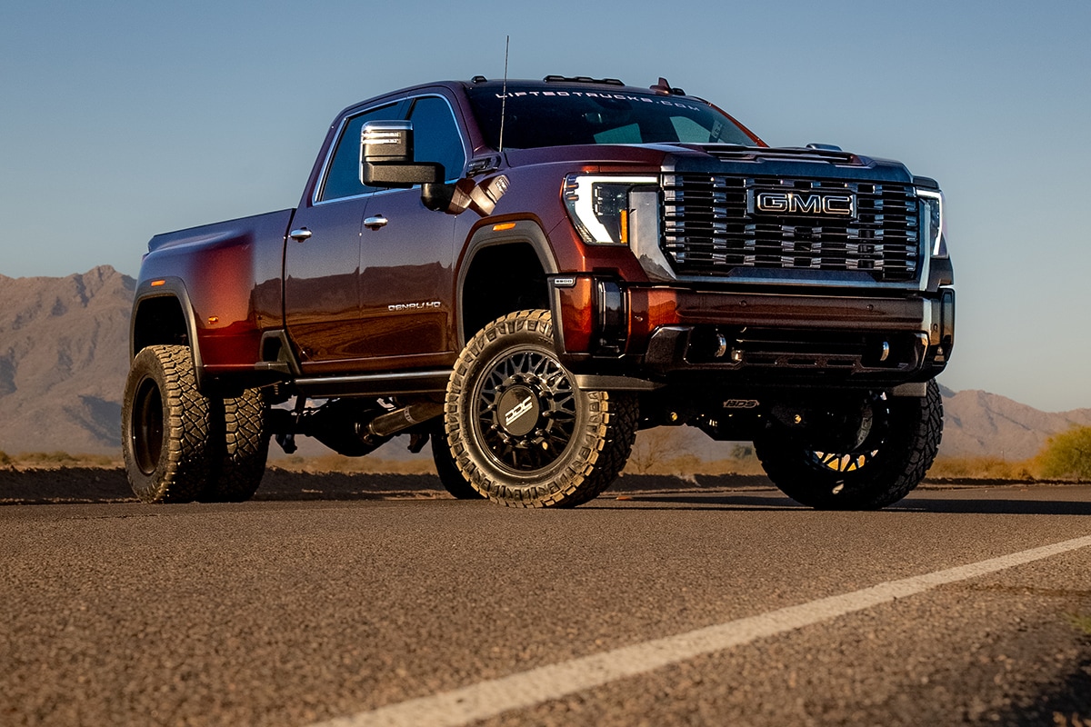 A customized GMC 3500 HD Denali parked on a desert road