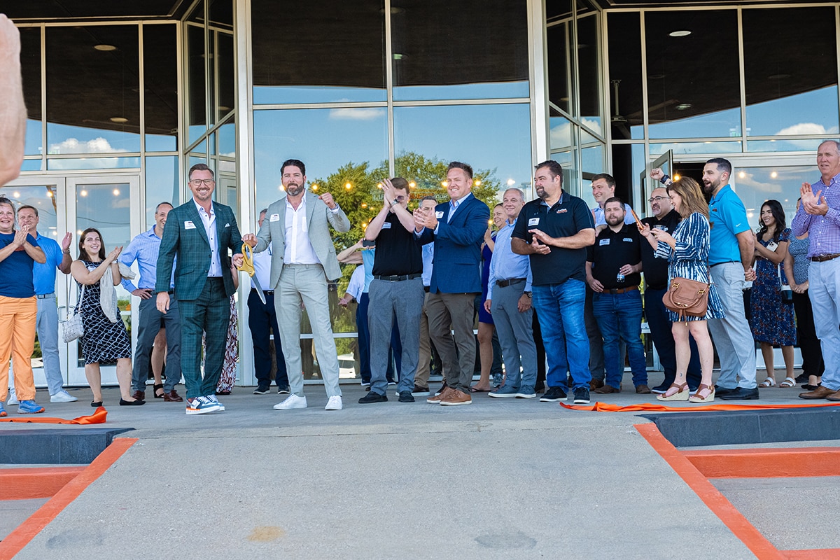  Lifted Trucks team members celebrating after a ribbon-cutting ceremony for a new location