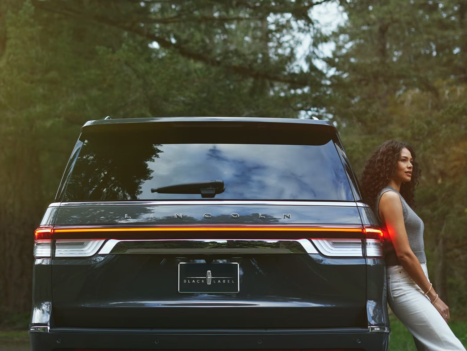A woman leans on a Lincoln Navigator® SUV.