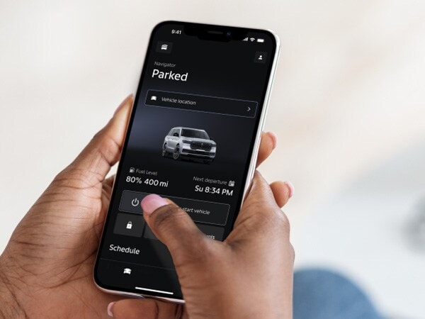 A woman holding a phone viewing the Lincoln app.