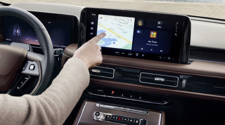 A person is tapping the center display touchscreen of a 2026 Lincoln Aviator<sup>®</sup> SUV.