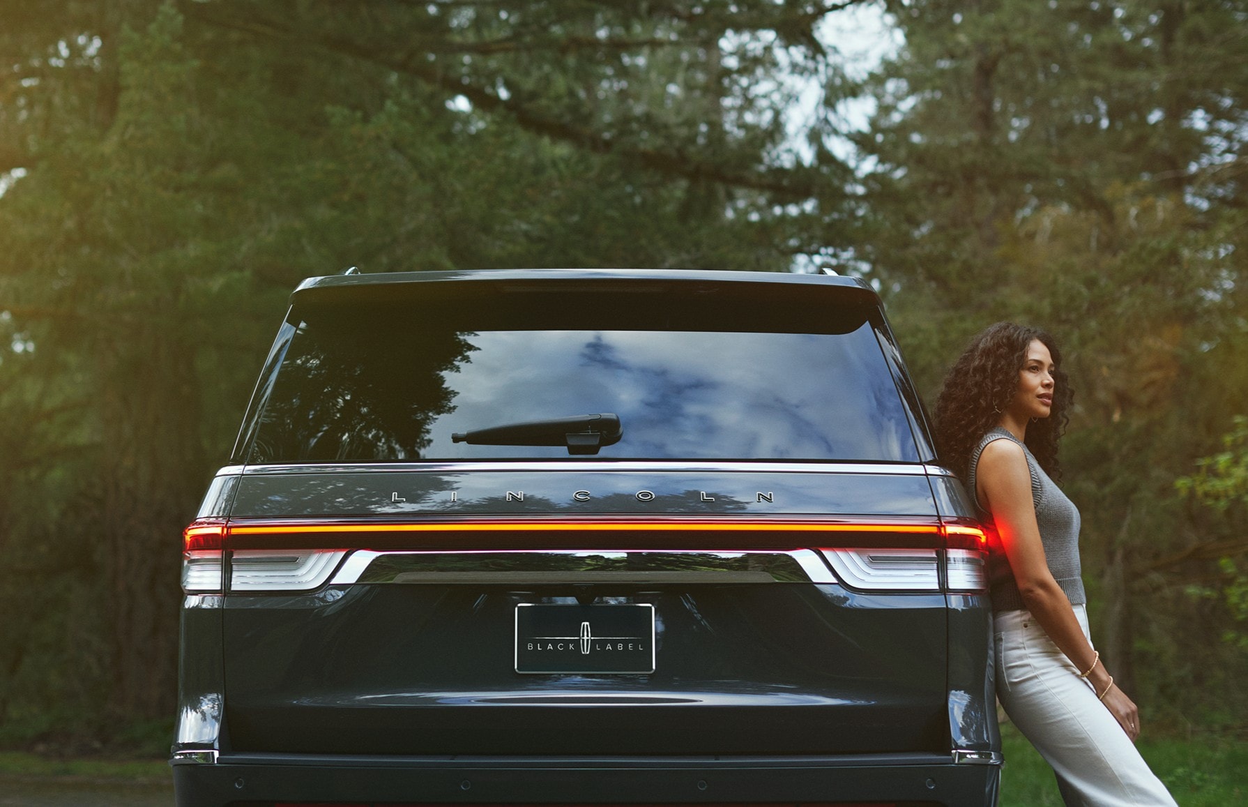 A woman leans on a Lincoln Navigator® SUV.