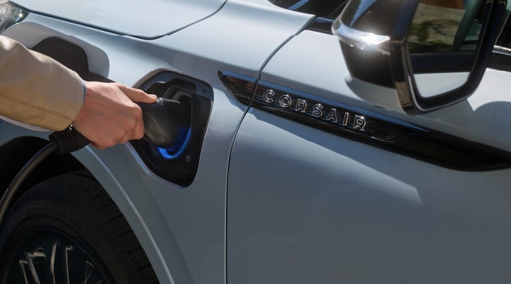 A hand is plugging in a 2026 Lincoln Corsair® Grand Touring Plug-in Hybrid SUV.