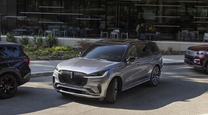 A gray 2025 Lincoln Black Label Aviator® SUV is shown in the process of parallel parking.
