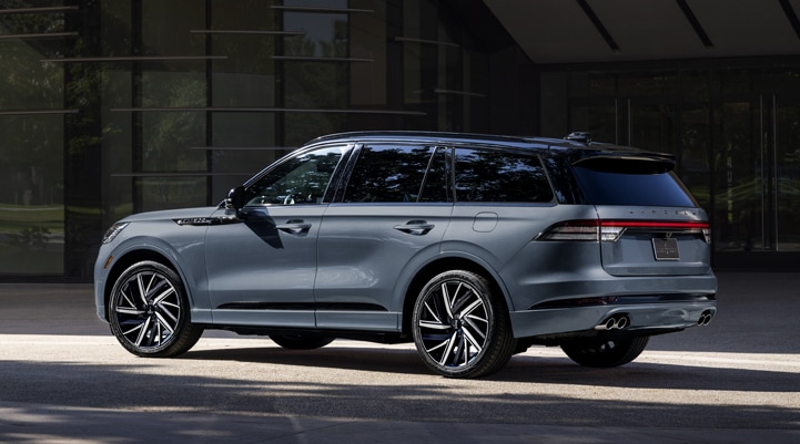 A Whisper Blue 2025 Lincoln Black Label AviatorĀ® SUV is parked outside a modern building.