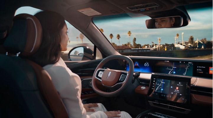 A person is shown driving hands-free on the highway with available Lincoln BlueCruise technology.