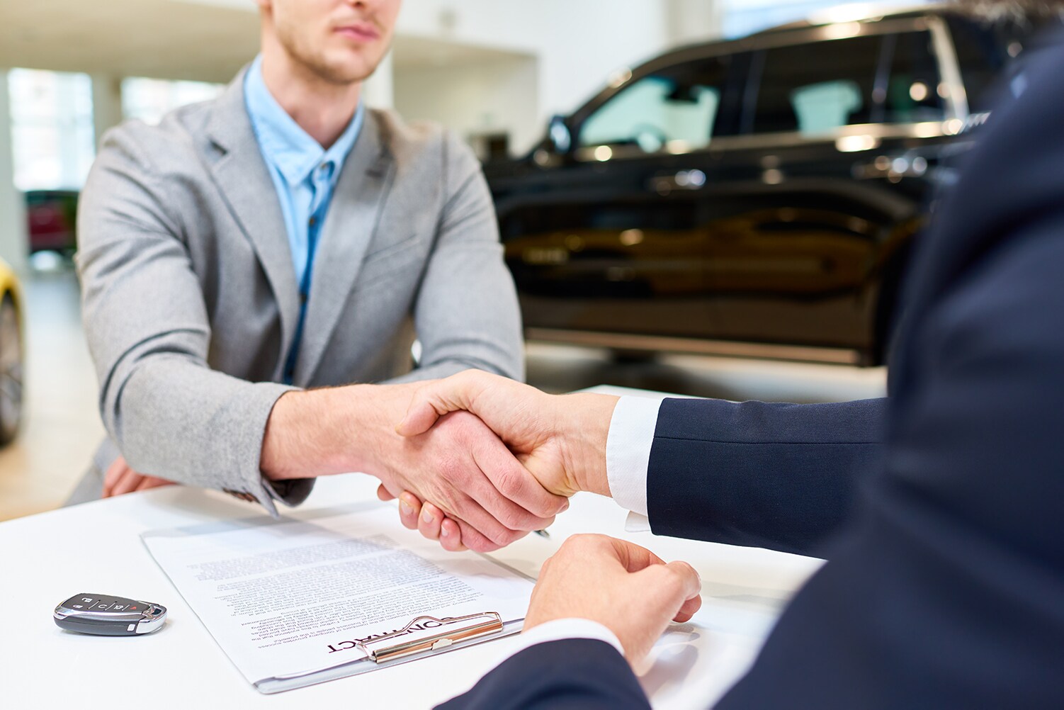 Lincoln of New Bern is a Car Dealership in New Bern near Neuse Forest, NC | Lincoln financial advisor shaking hands with customer at sales desk