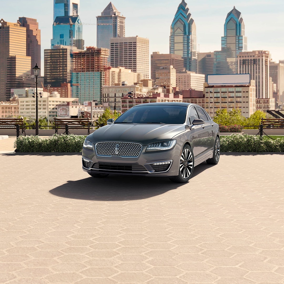 Comparison of the 2020 Lincoln MKZ vs the 2020 Cadillac CT5 at Lincoln of New Bern | Grey Lincoln MY20 MKZ parked in a park outside city