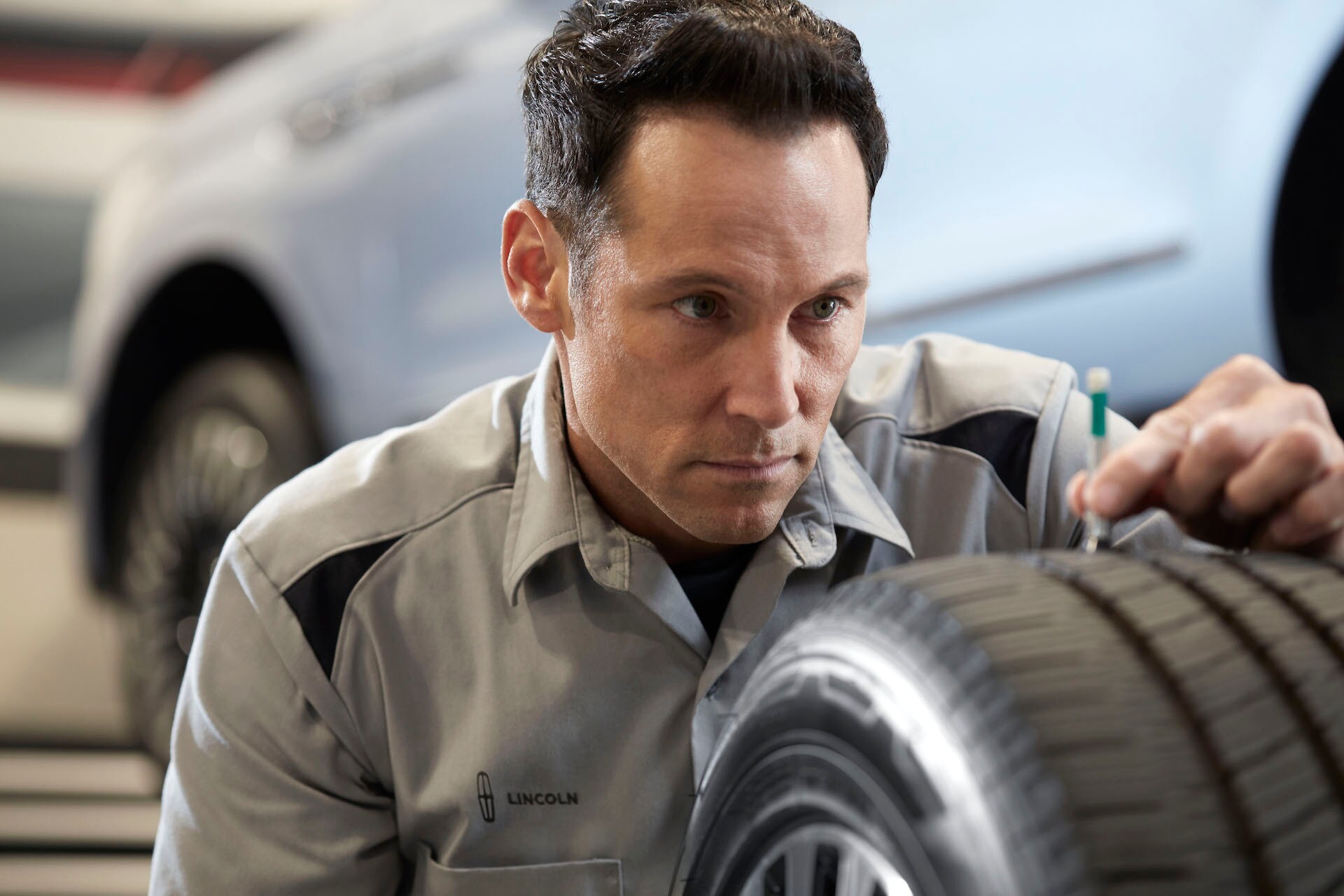 Lincoln of New Bern is a Car Dealership in New Bern near Grantsboro NC | Lincoln service technician inspecting tire treads