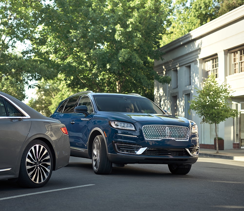 Lincoln of New Bern is a Car Dealership in New Bern near Brices Creek NC | Navy 2020 Lincoln Nautilus driving through parking lot