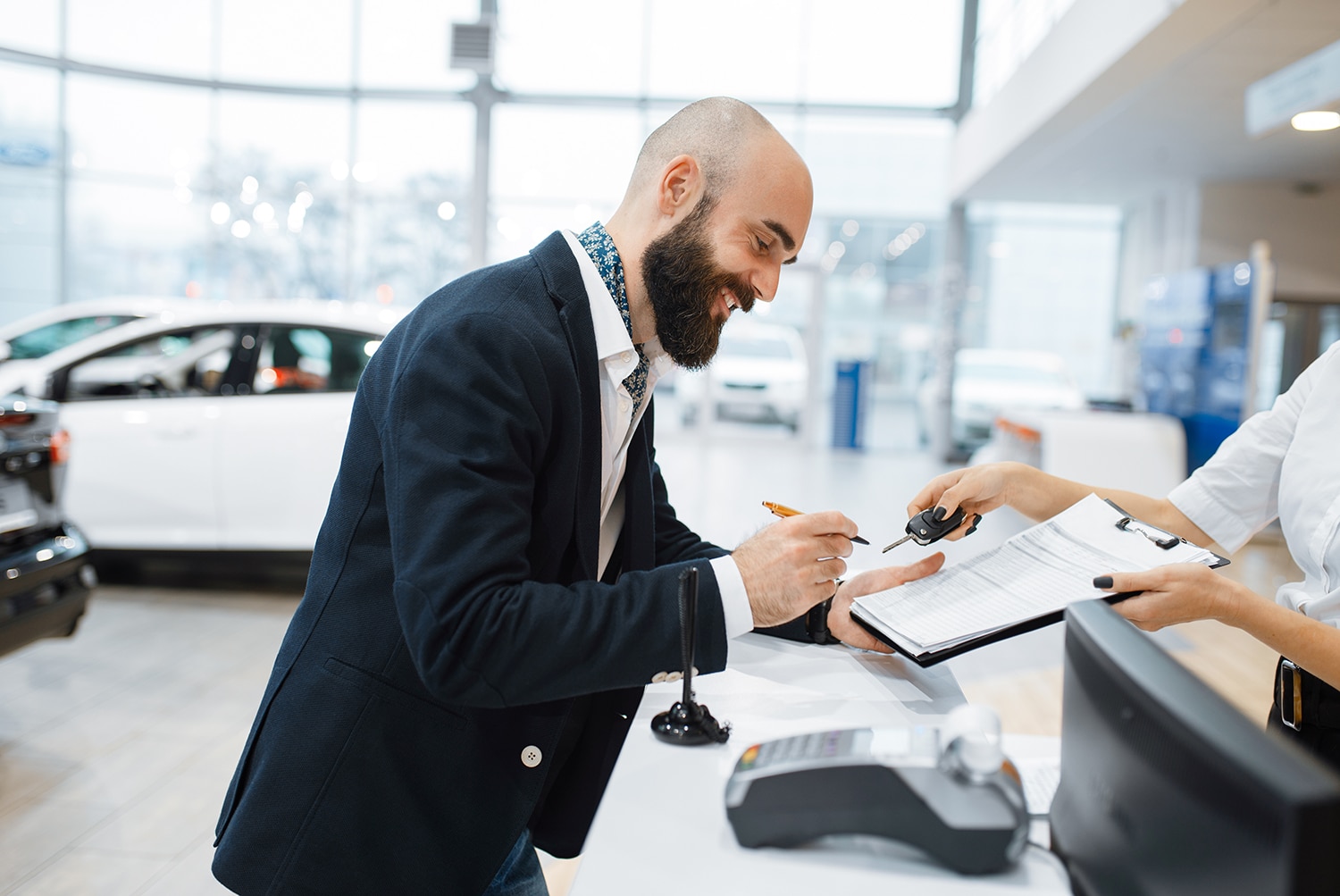 Lincoln of New Bern is a Car Dealership in New Bern near Bridgeton, NC | Lincoln financial advisor shaking hands with customer at sales desk