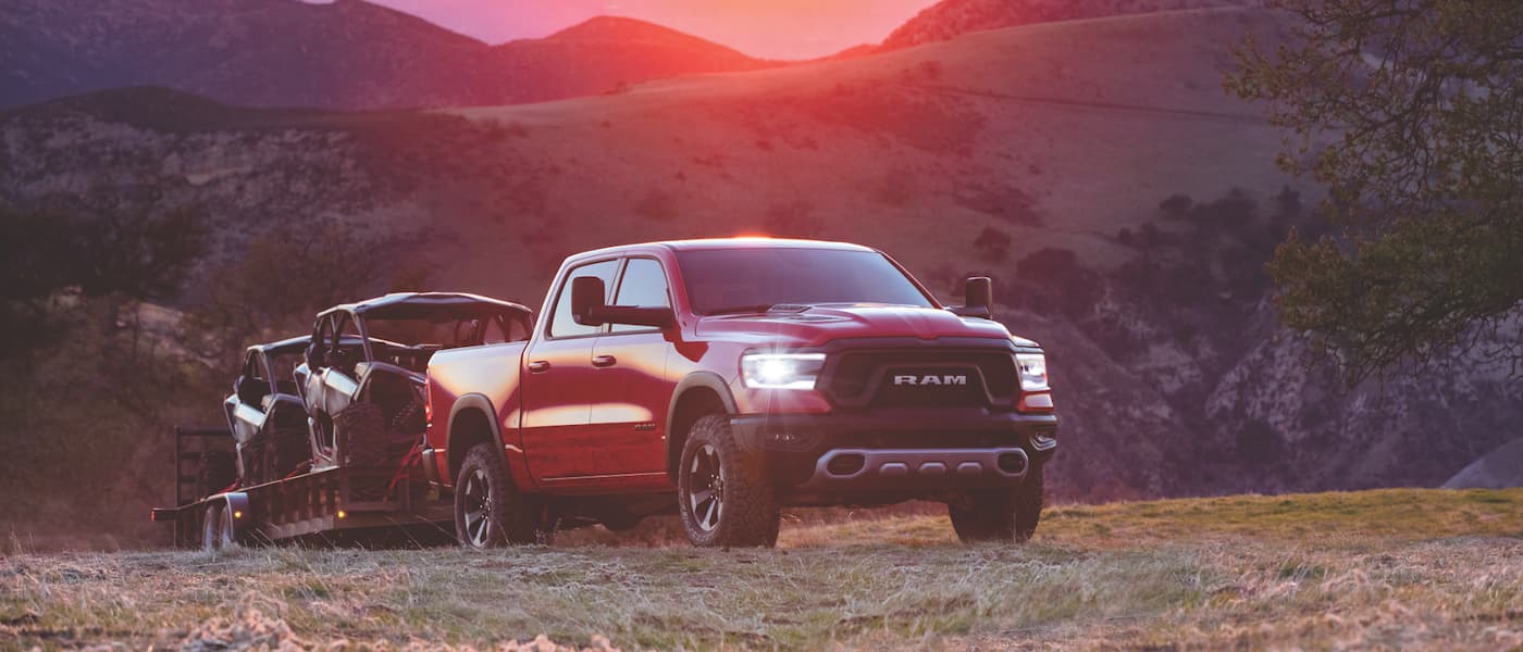 Red Ram 1500 towing two boats over a hill