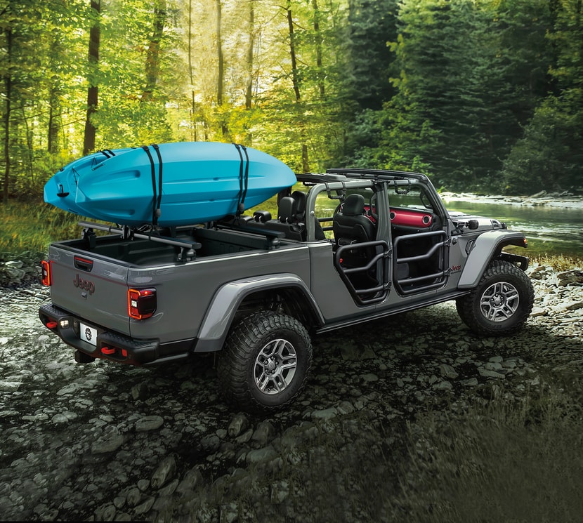 Jeep-Gladiator-Lifestyle-25.png grey Jeep Gladiator parked at a river with a kayak in the bed