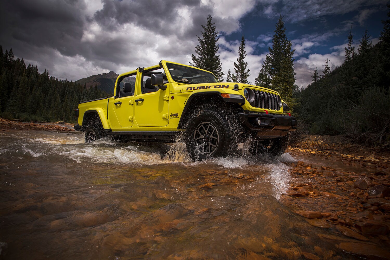 2024 Jeep Gladiator yellow Jeep Gladiator truck driving through a stream