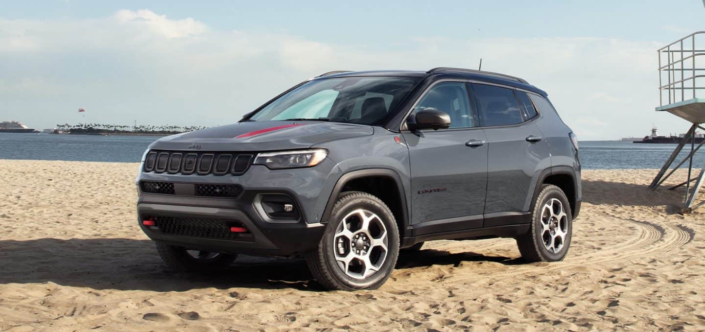 grey Jeep Compass SUV parked at the beach