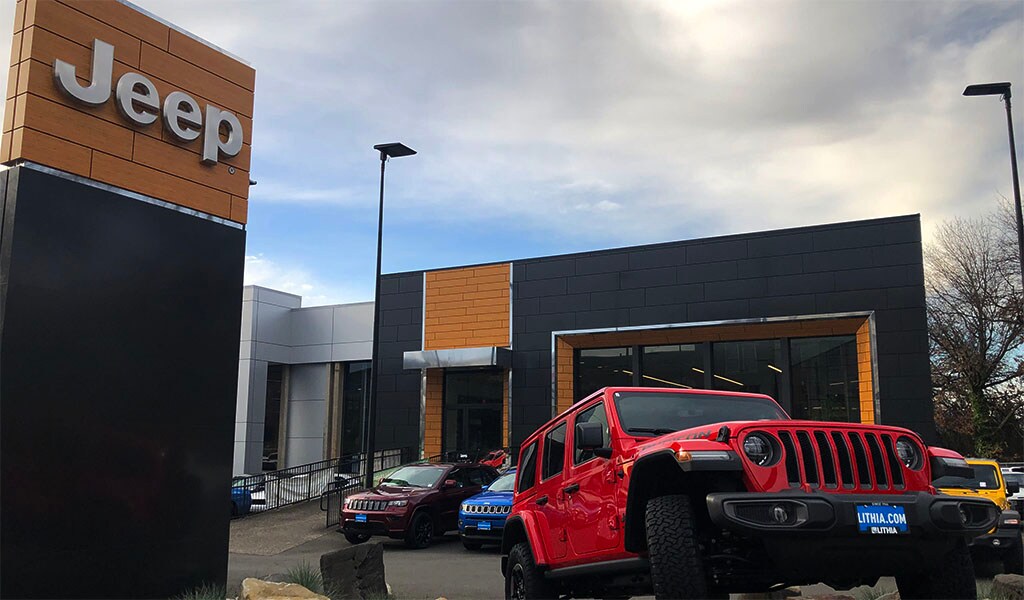 The Lithia Jeep Portland store in the background with a red Jeep in front.