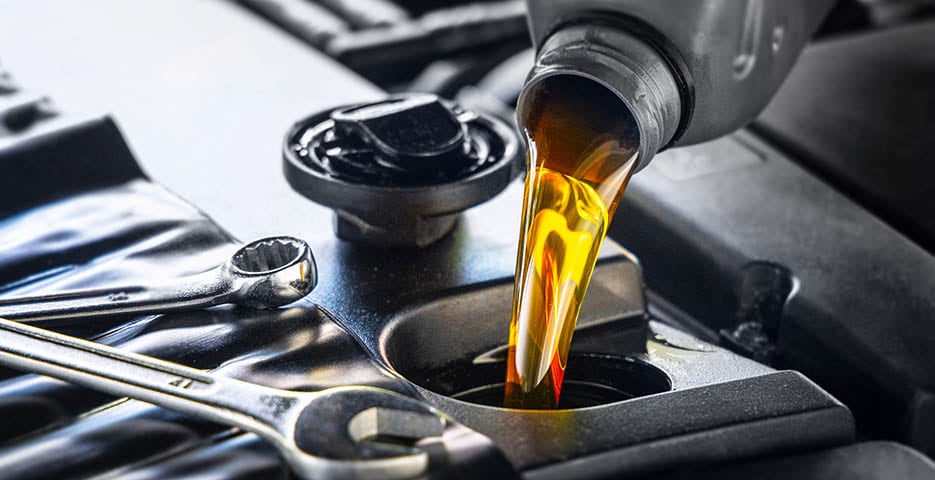 Fresh Oil being poured in to an engine during an oil change.