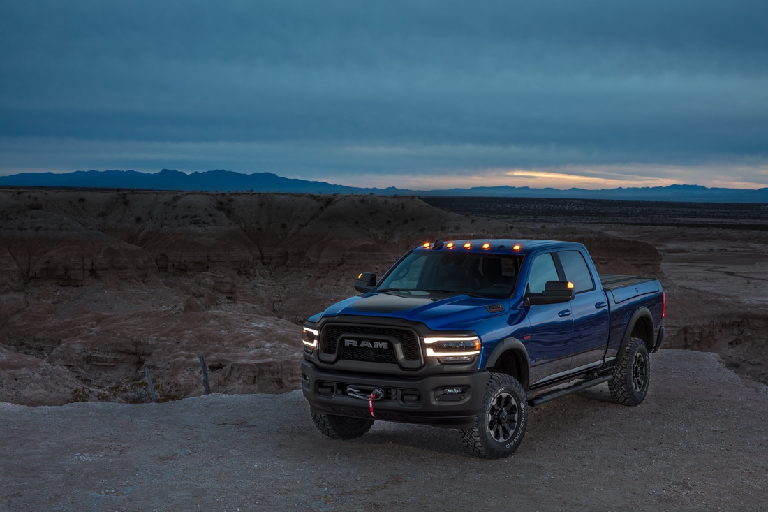 blue Ram 2500 Power Wagon crew cab truck parked in a desert at dusk