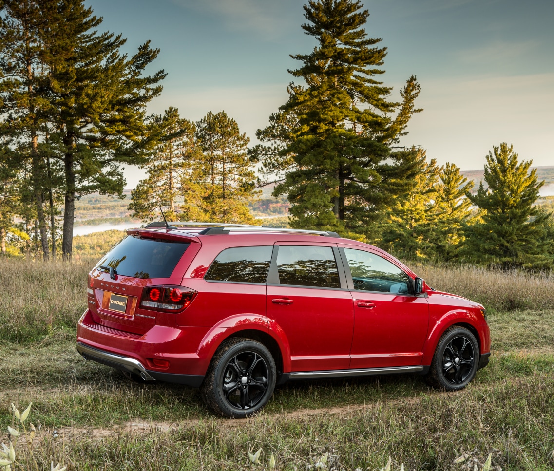 red Dodge Journey SUV parked in a grassy field