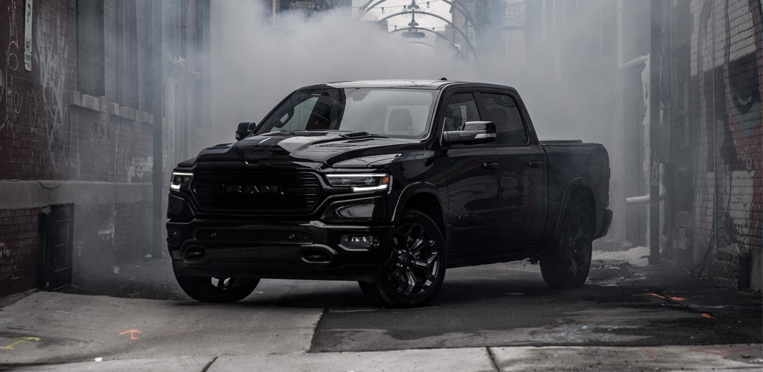 black Ram 1500 truck parked in an alleyway with steam behind it
