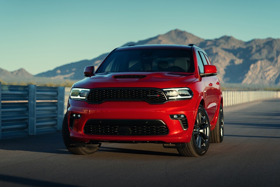 red Dodge Durango parked in front of a fence