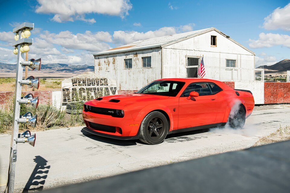 red Dodge Challenger parked at an abandoned race track