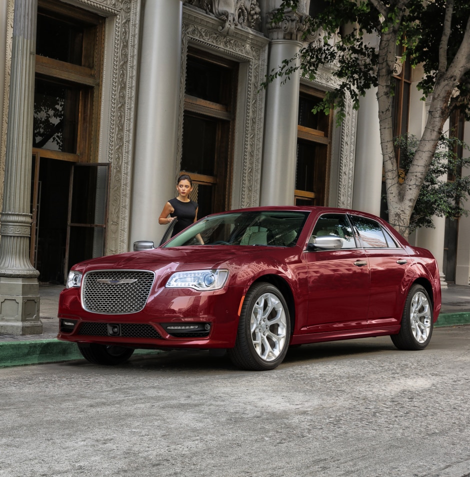 red Chrysler 300 sedan parked in front of large pillared building