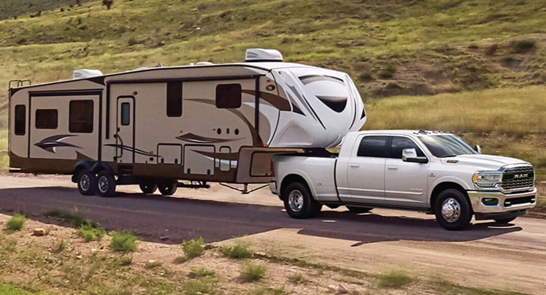white Ram 3500 truck towing a large trailer