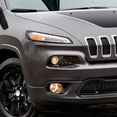 The front corner of a new Jeep Cherokee, showing a wheel and a headlight