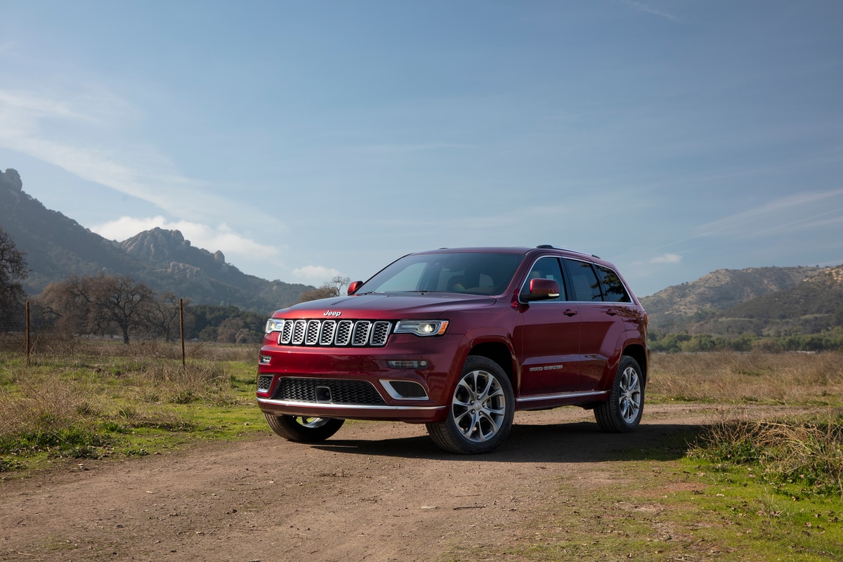 dark red Jeep Grand Cherokee SUV parked on a rocky hilltop