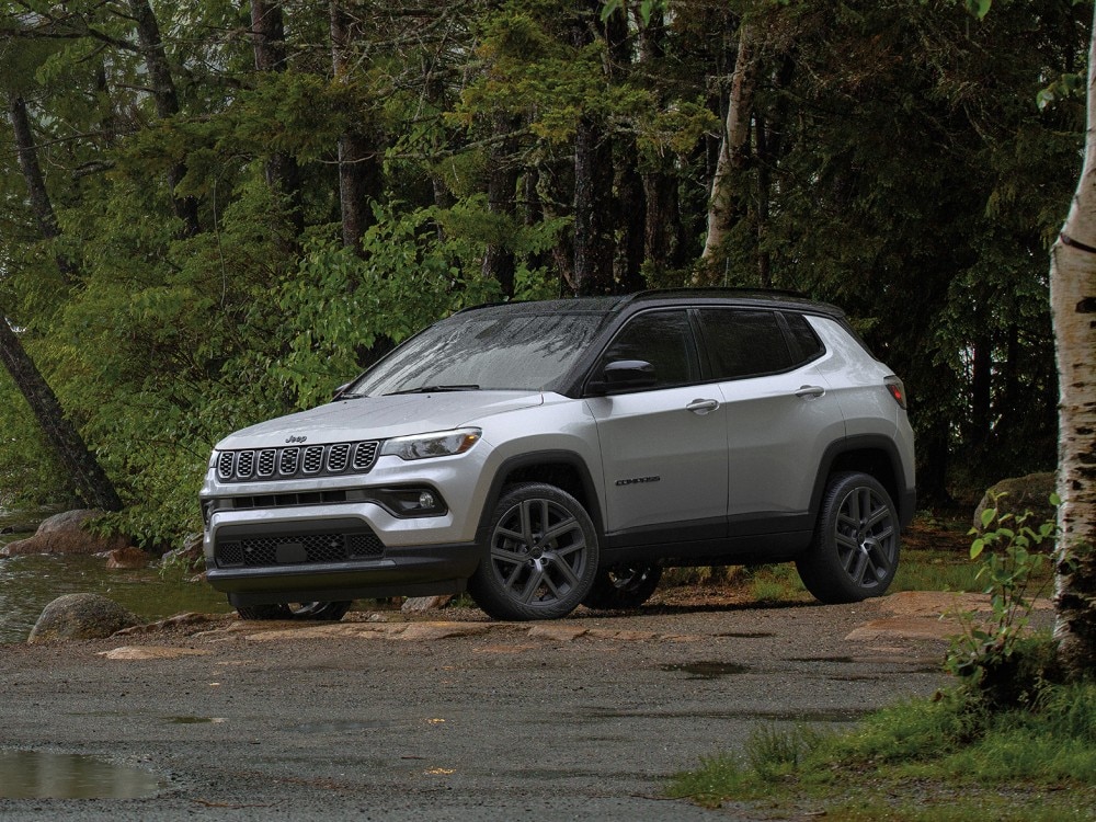 white Jeep Compass coming around a foggy hill