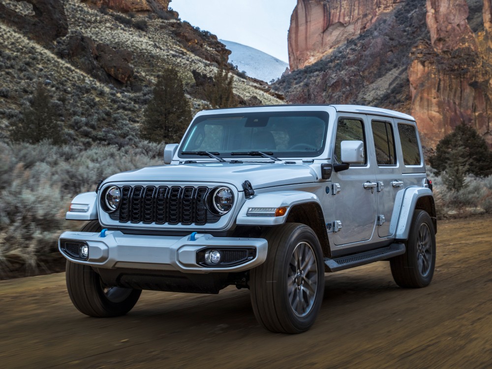red Jeep Grand Cherokee driving through a wooded area