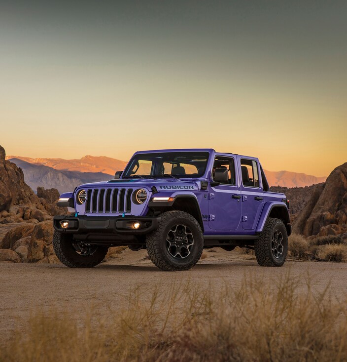 purple Jeep Wrangler 4xe SUV parked in a desert at sunset