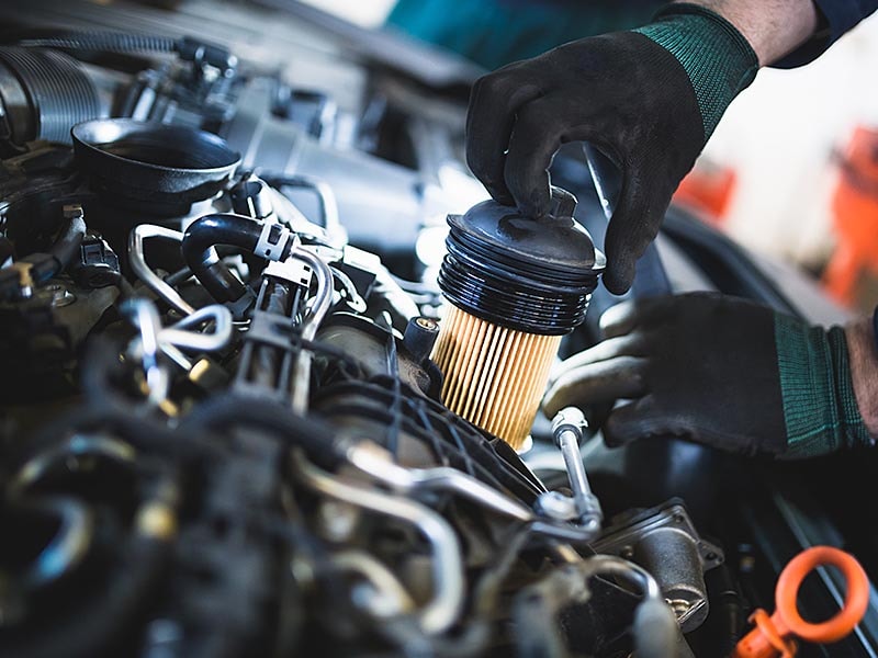 Service technician removing fuel filter.