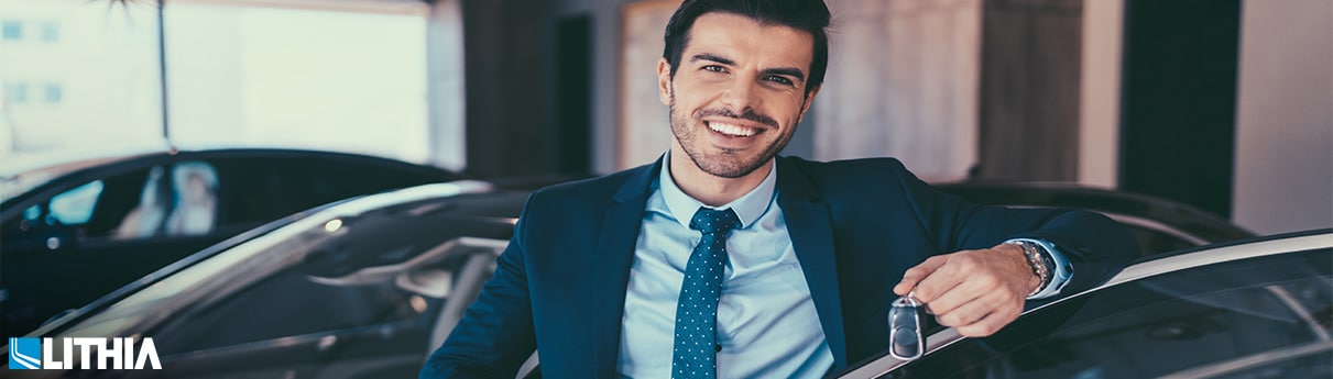 Salesman showing keys to new car