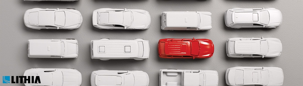 Red Car standing out in a group of gray cars