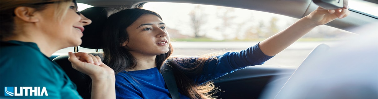 Teen with mom looking in rearview mirror